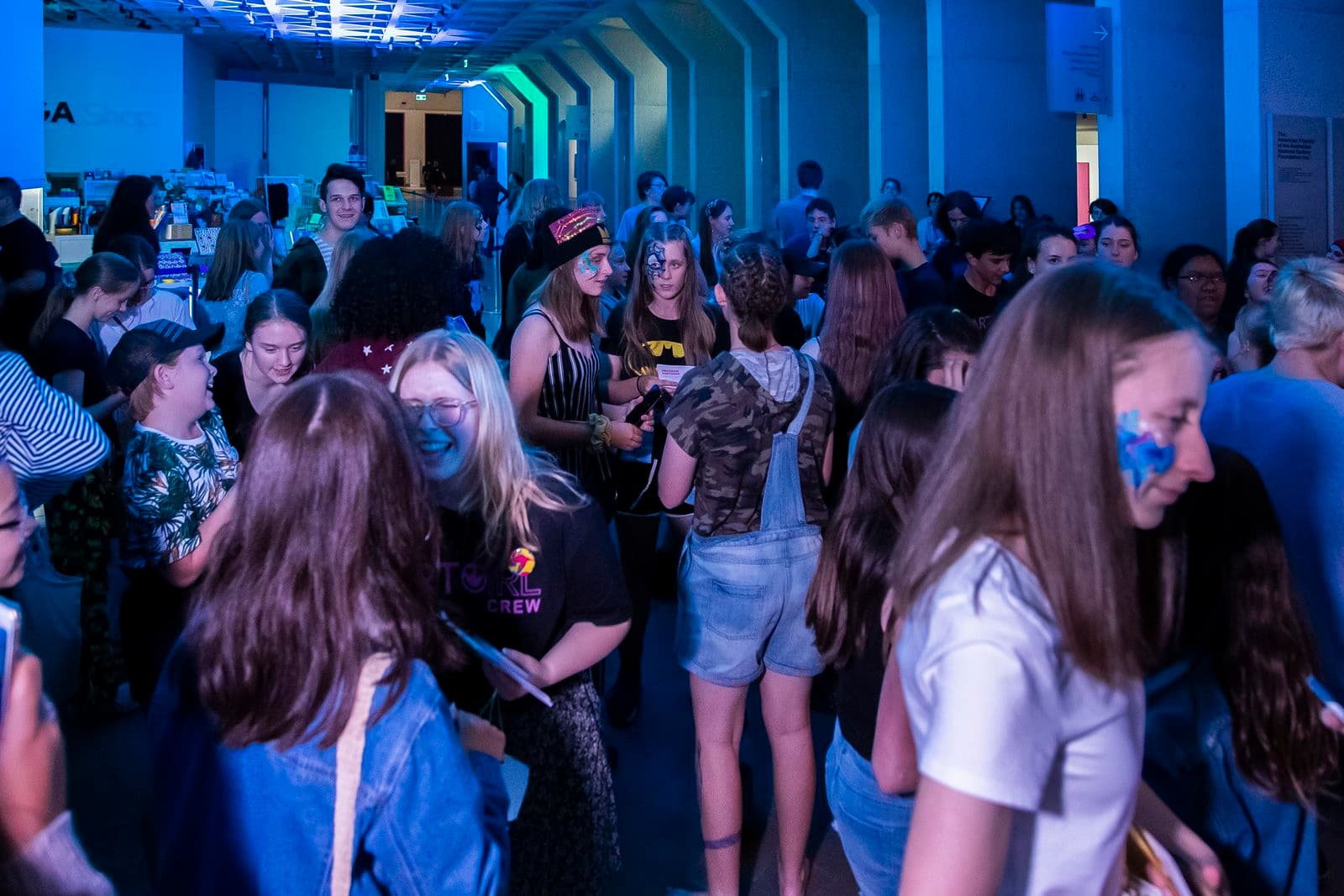 Group of young people laughing and chatting to each other in the foyer at the National Gallery of Australia