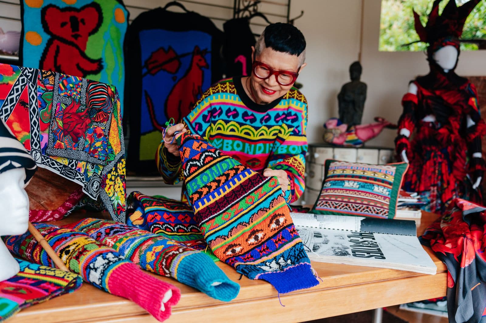 A picture of Jenny Kee in a brightly coloured knit jumper.