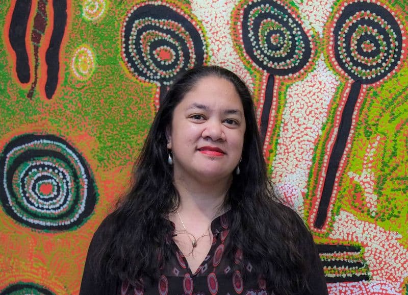Portrait of a woman standing in front of artwork in an Art Gallery