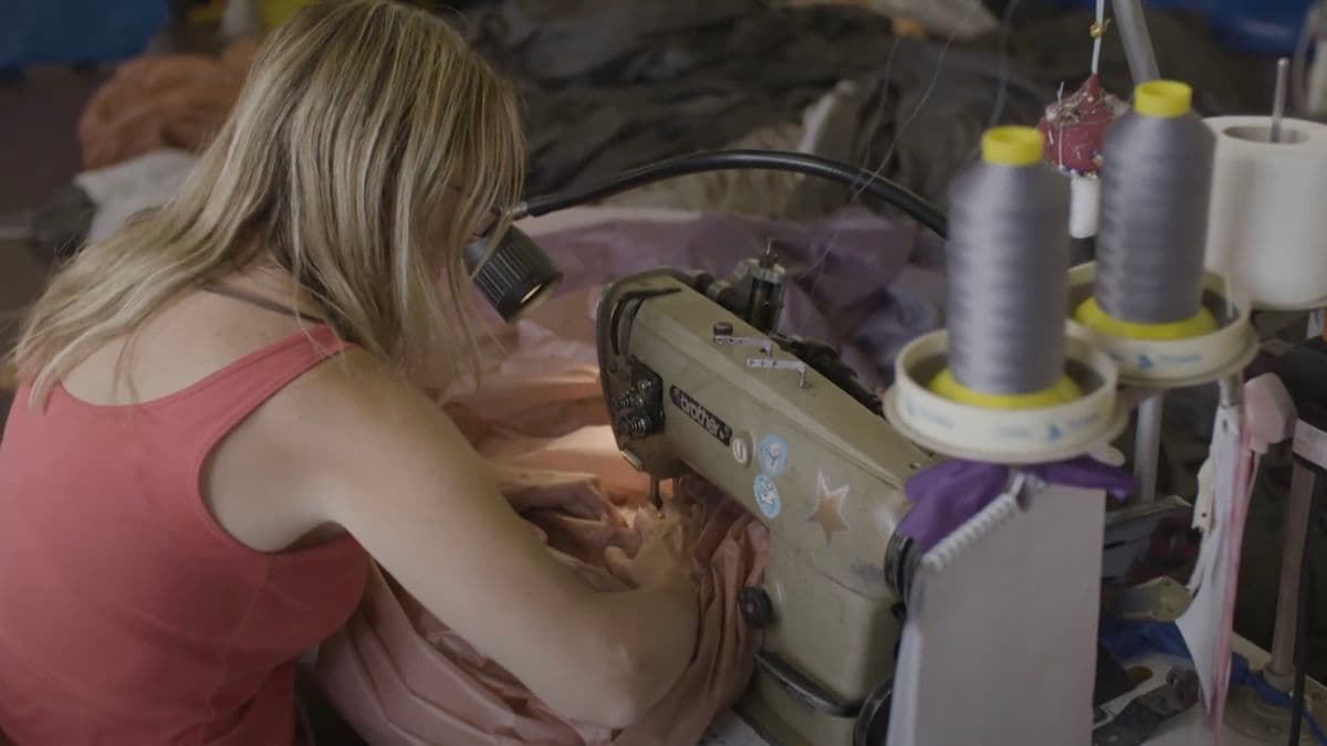 Video still of lady using sewing machine.