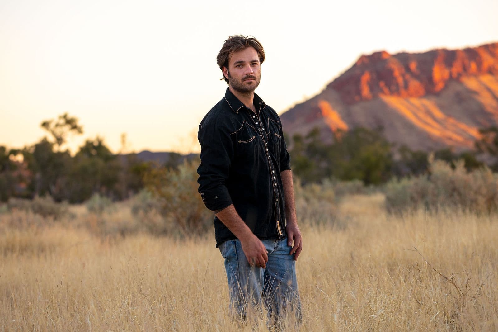 A portrait of Dylan River standing outside.