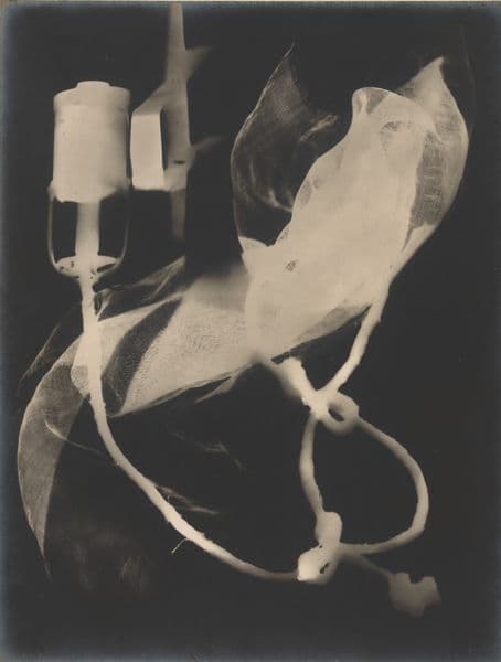 A sepia toned photogram showing the shadow of a piece of threadbare cloth and a cord. It is very difficult to see what this is exactly.