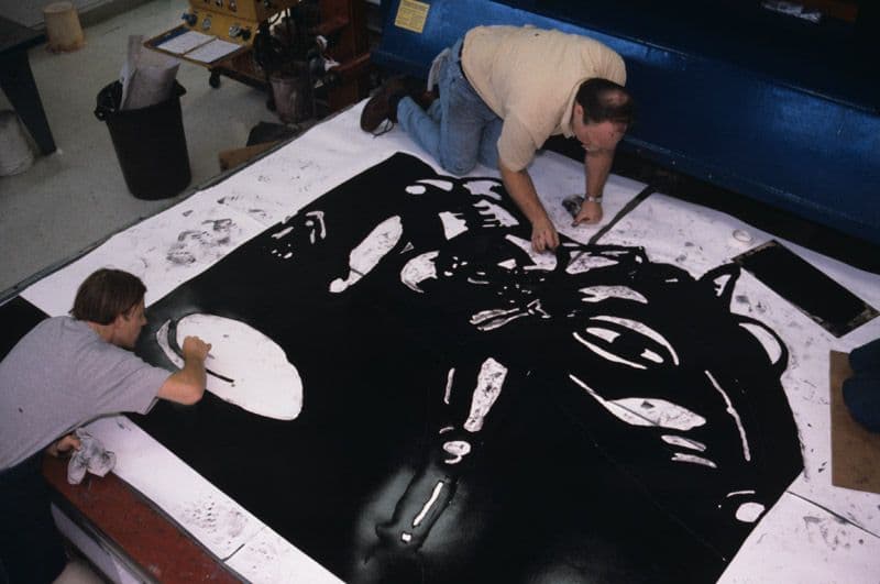 Black and white photograph of John Hutcheson and Christian Farrell wiping excess ink from newly inked linocut for Per Inge Bjorlo Ride