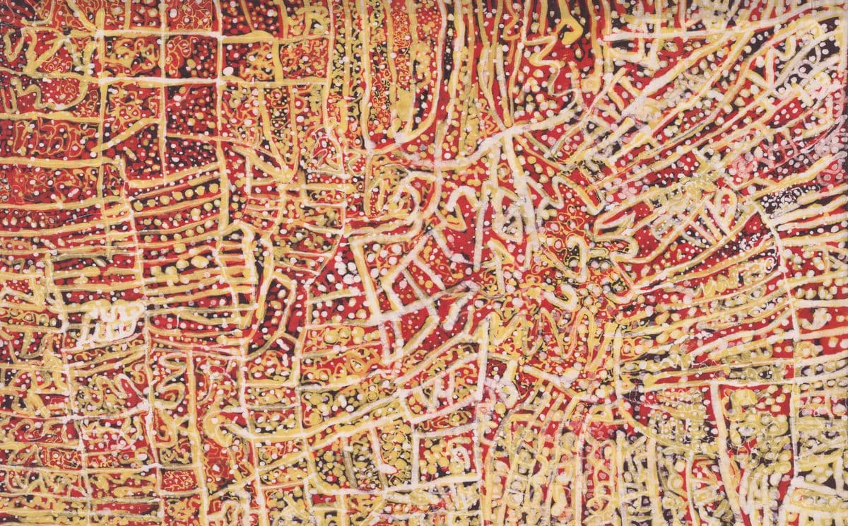 A batik painting in reds and yellows with lines and dots.