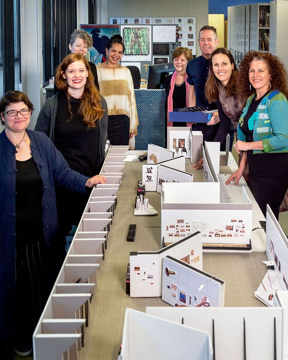 A team of eight people around a model of new gallery spaces