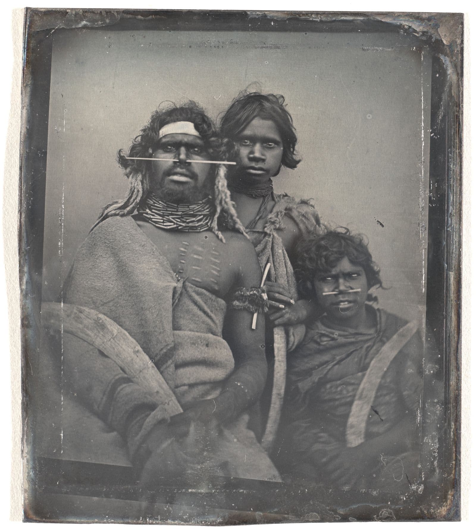 Photograph of an Indigenous Australian man in traditional dress and two younger children also in traditional clothing
