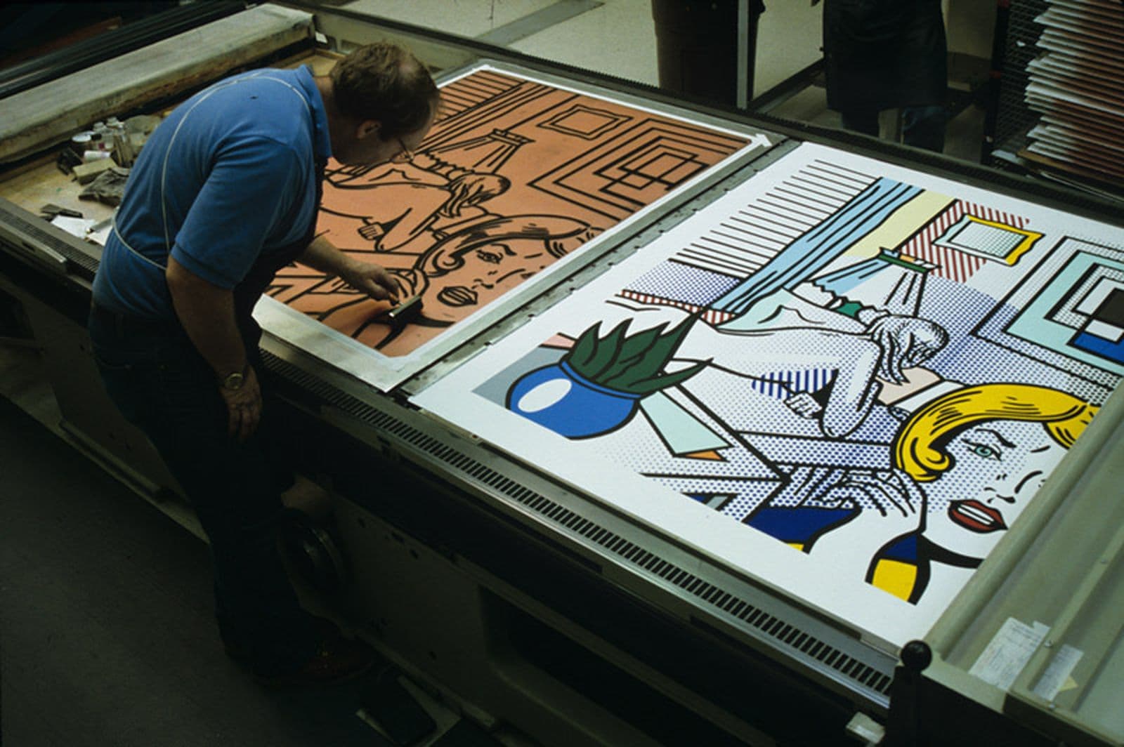 Colour photograph of Josh Hutcherson using a brayer to ink Roy Lichtenstein's 'Roommates' print