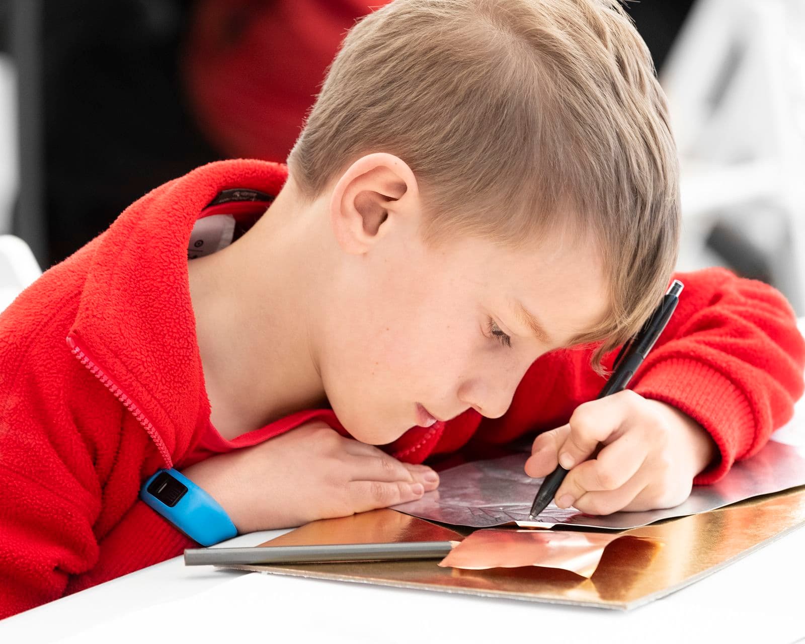 Close up photograph of child artmaking at table