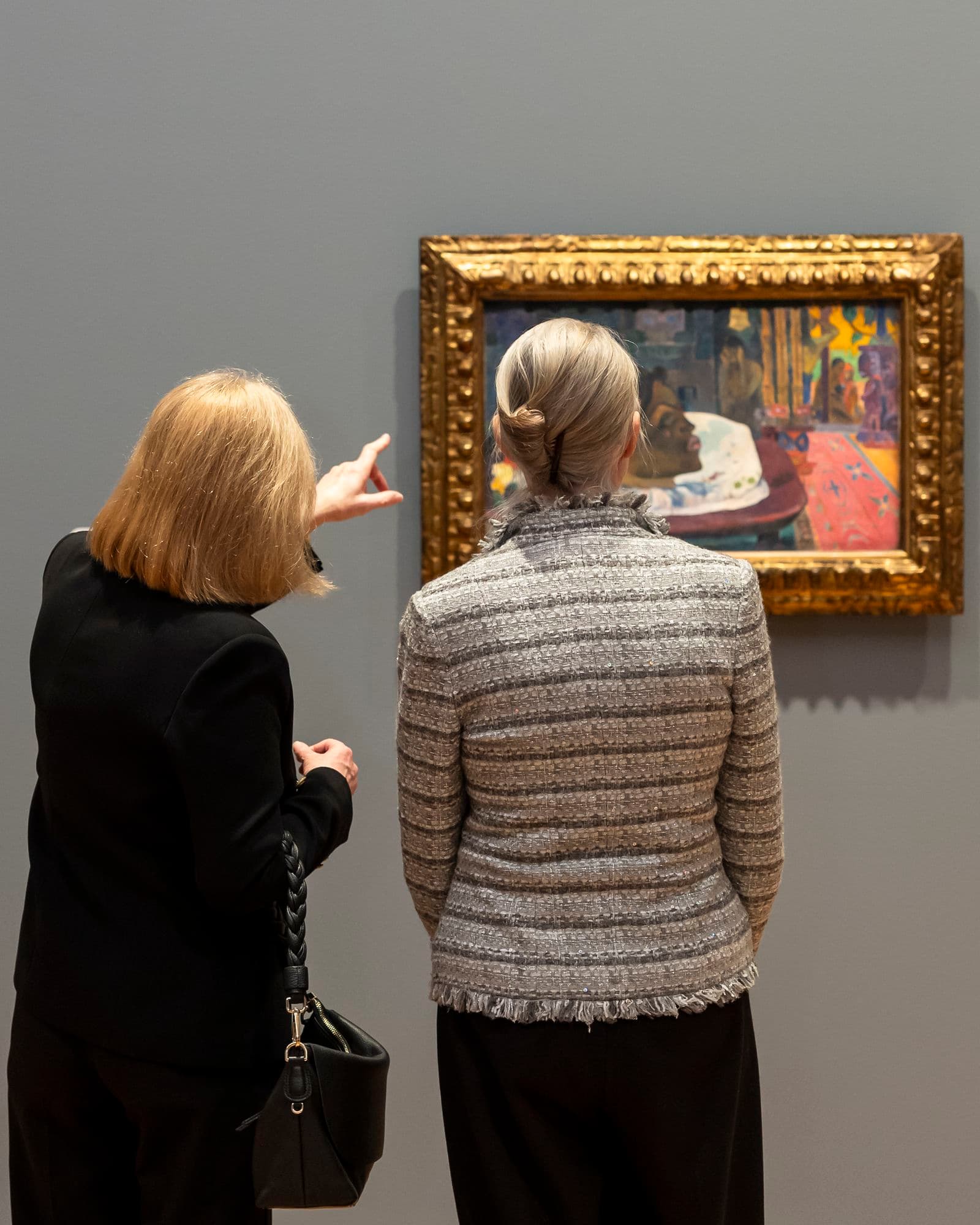 People looking at Gauguin's painting at the National Gallery of Australia.
