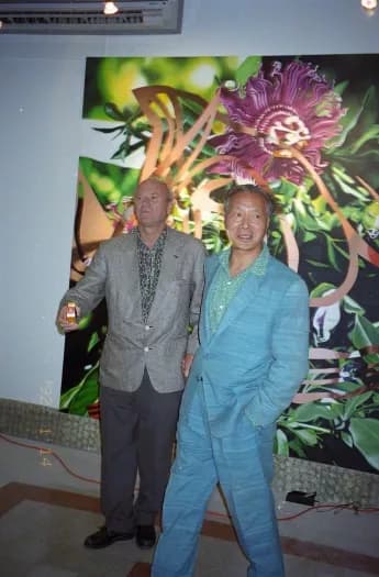 Colour photograph of James Rosenquist and Walasse Ting in front of colourful artwork