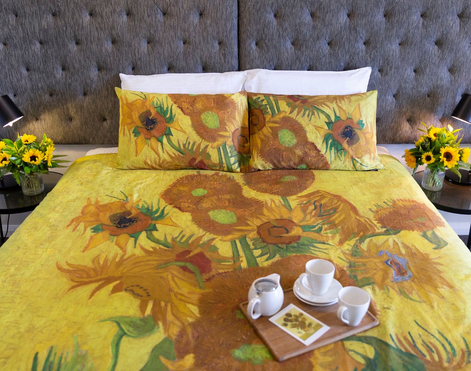 A photograph of a double bed made with sheets printed with Van Gogh's Sunflowers