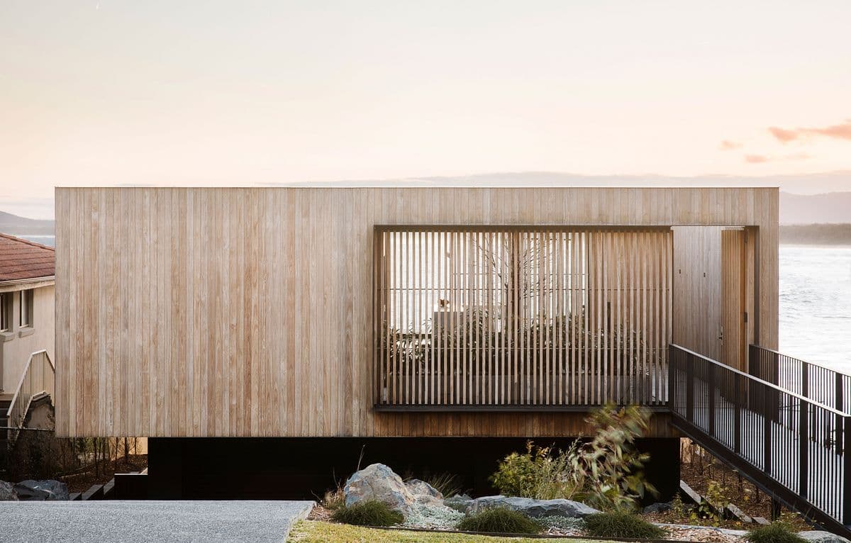 Photograph of wooden building with beach in the background