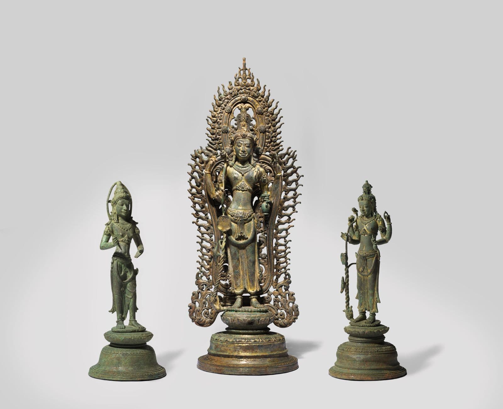A picture of three bronze sculptures of Cambodian deities