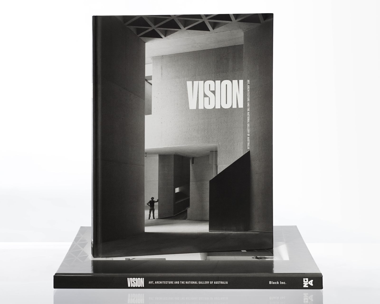 Image of a large book with a black and white photo of a building interior with the word VISION overlaid in white capital letters