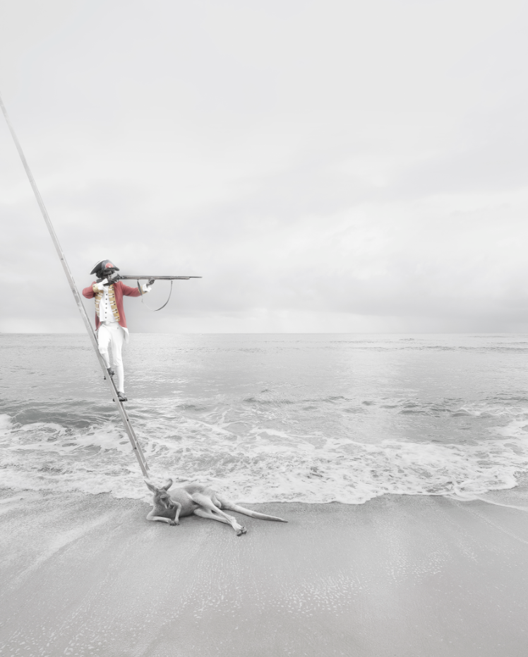 Photo of an Aboriginal man dressed in colonial-style clothing acting as a British coloniser holding a muscat as he descends from a ship ladder accompanied by a kangaroo at the shore