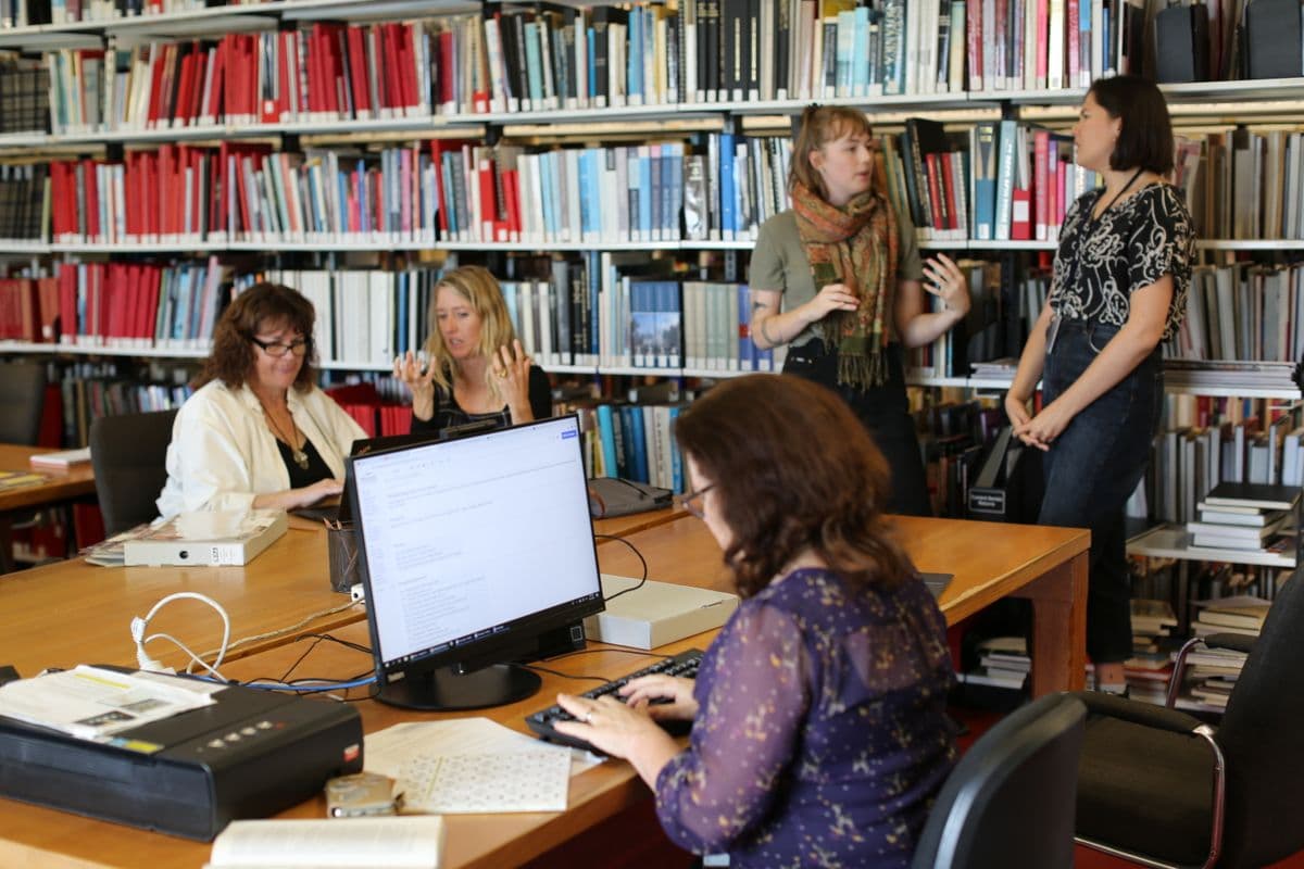 Photograph of people sitting and standing in library space