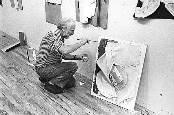 Black and white photograph of Anthony Caro painting in his studio