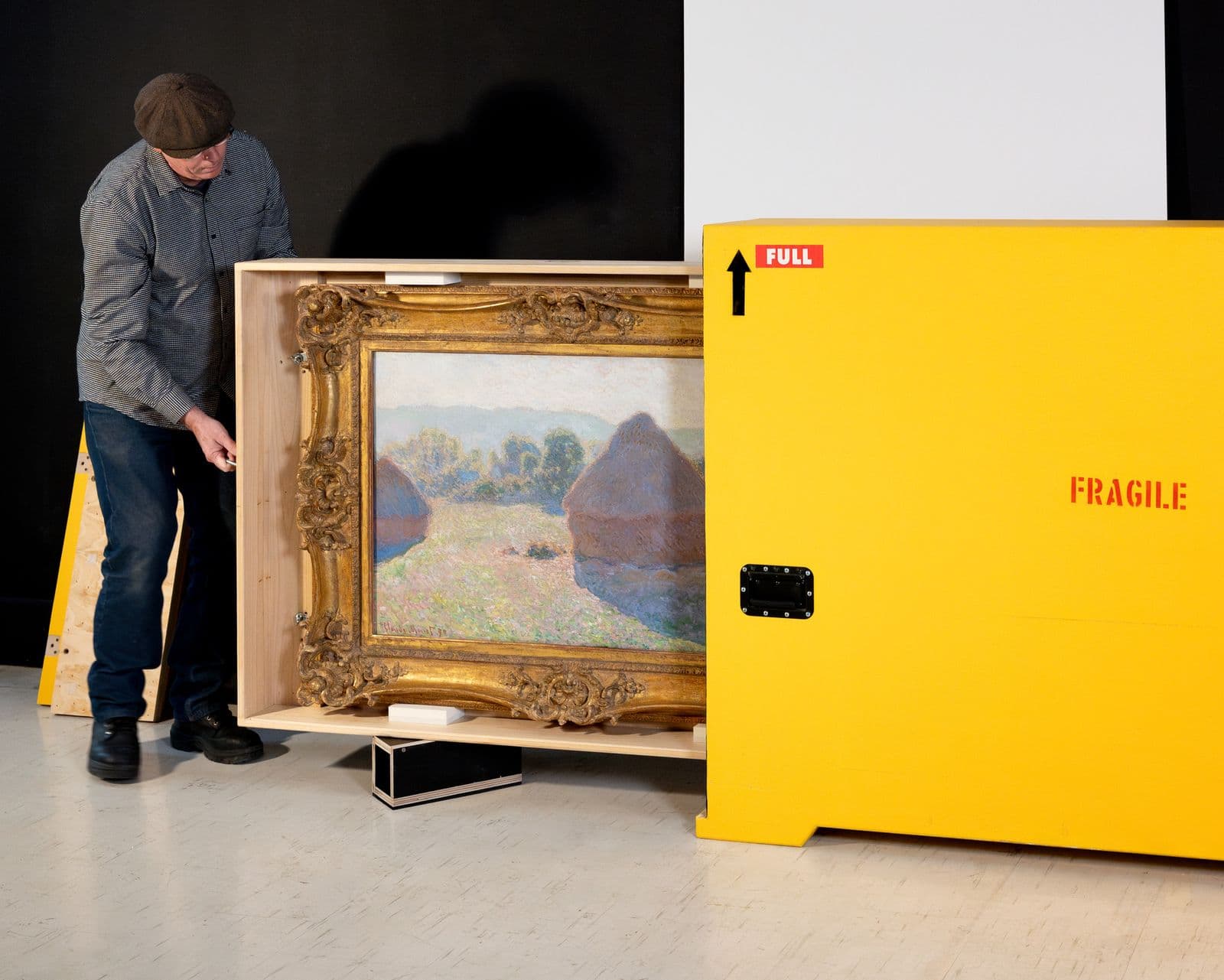 A person moves Claude Monet's Haystacks from a packing box