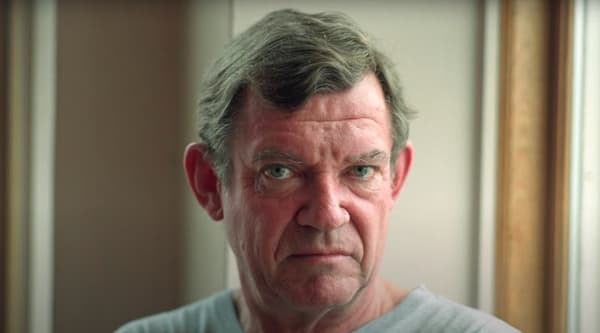 a screenshot of a video showing a close-up image of the art critic Robert Hughes.