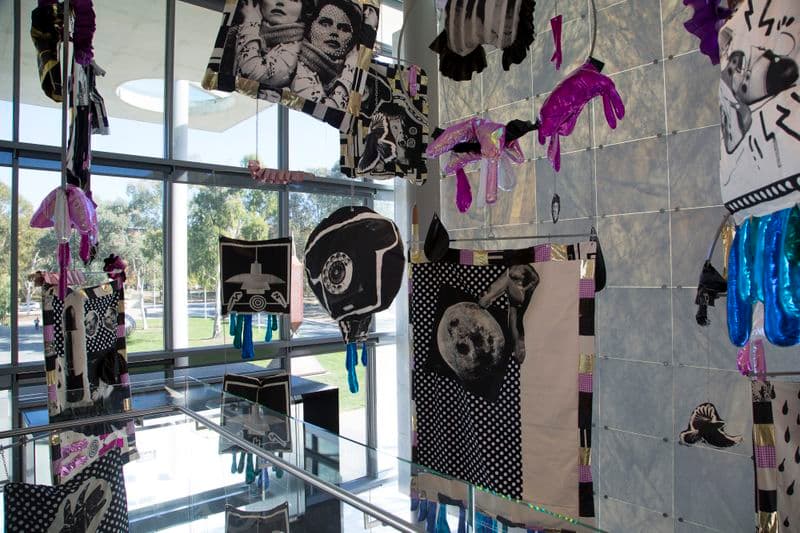Brightly coloured objects hang from the ceiling of a largo foyer