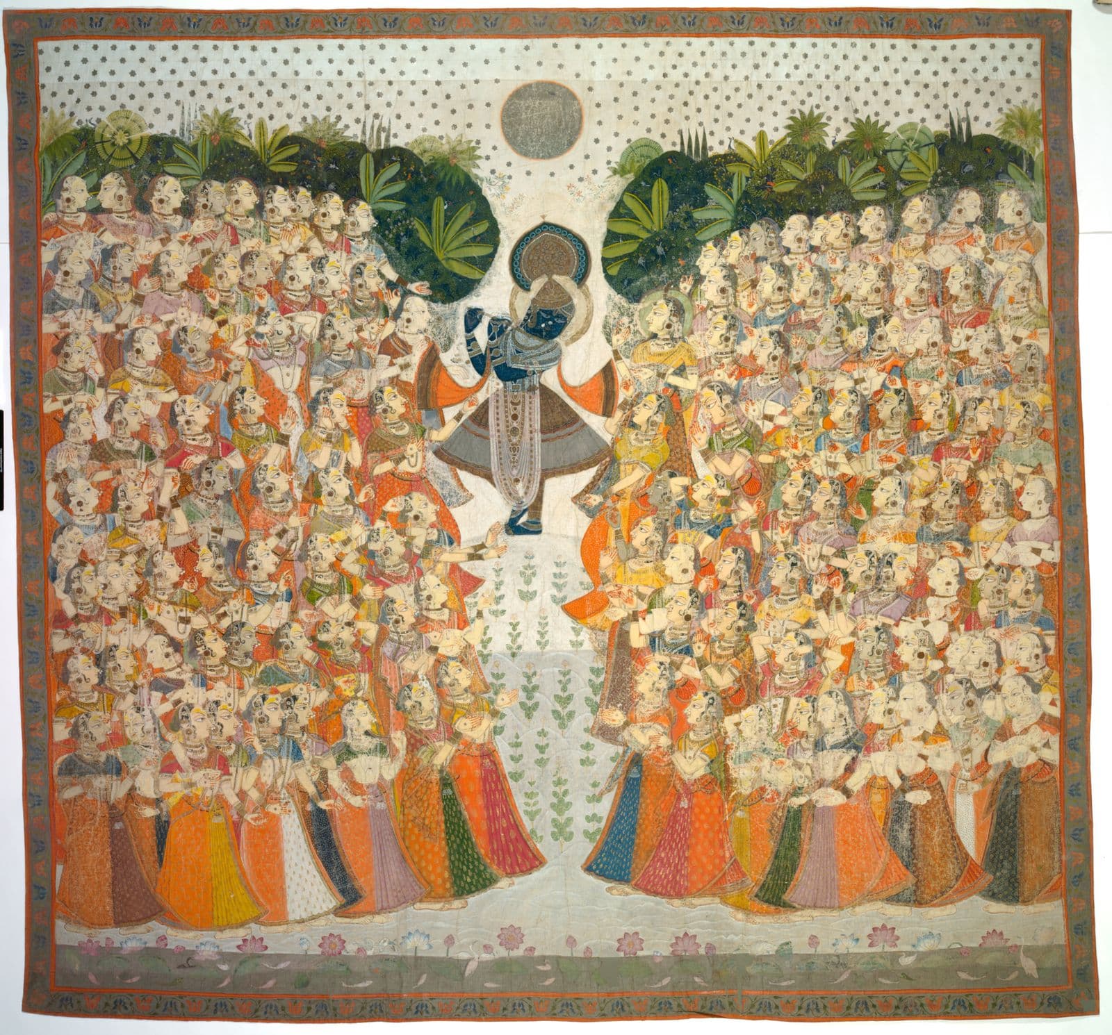 A central blue figure, Krishna, plays the flute as he is surrounded by people in multicoloured clothing