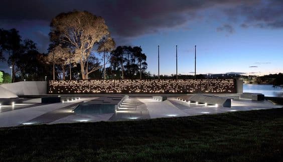 Photograph of memorial at night with small lights in distance