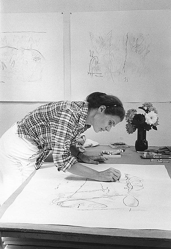 Black and white photograph of Nancy Graves drawing in her studio