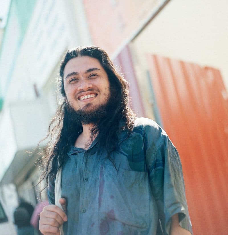 Portrait image of young man with long dark hair and beard