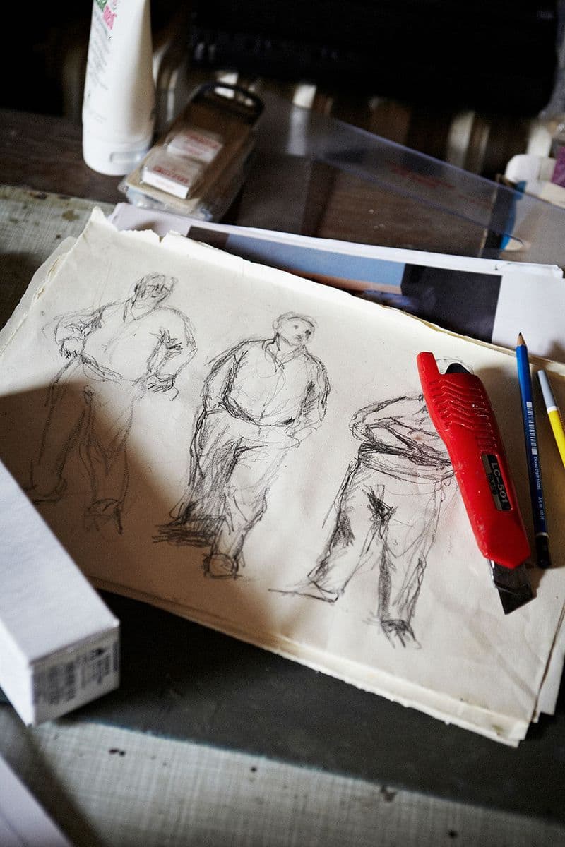 A photograph of three sketches of a figure standing