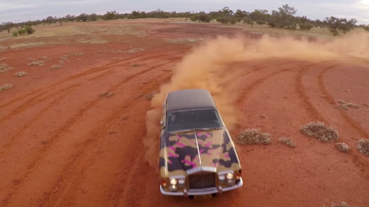 A video still of a car driving through the desert