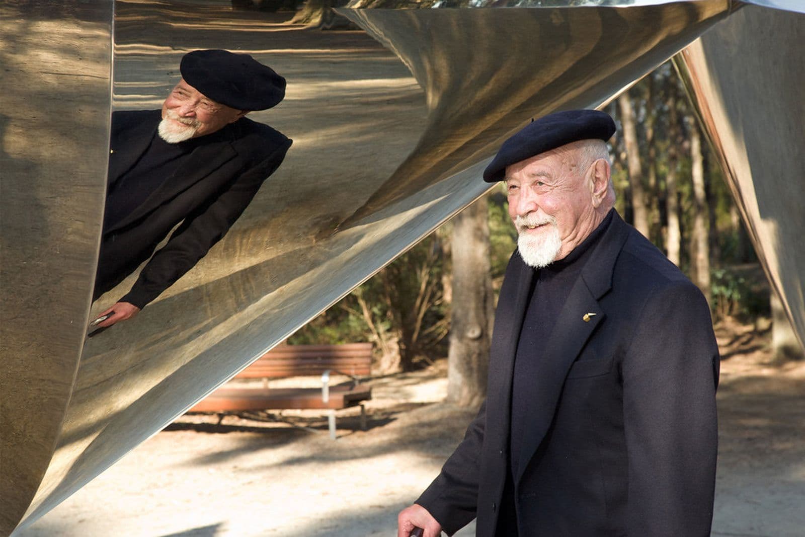 The artist Bert Flugelman standing in front of  Cones - a large-scale sculpture of seven steel cones.