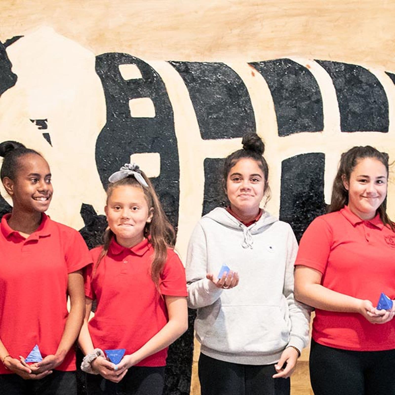 Group of Primary school girls standing in front of a work of art