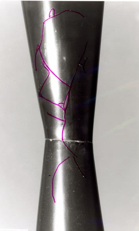 Black and white image of a bacl sculpture, with details of cracks digitally highlighted in purple