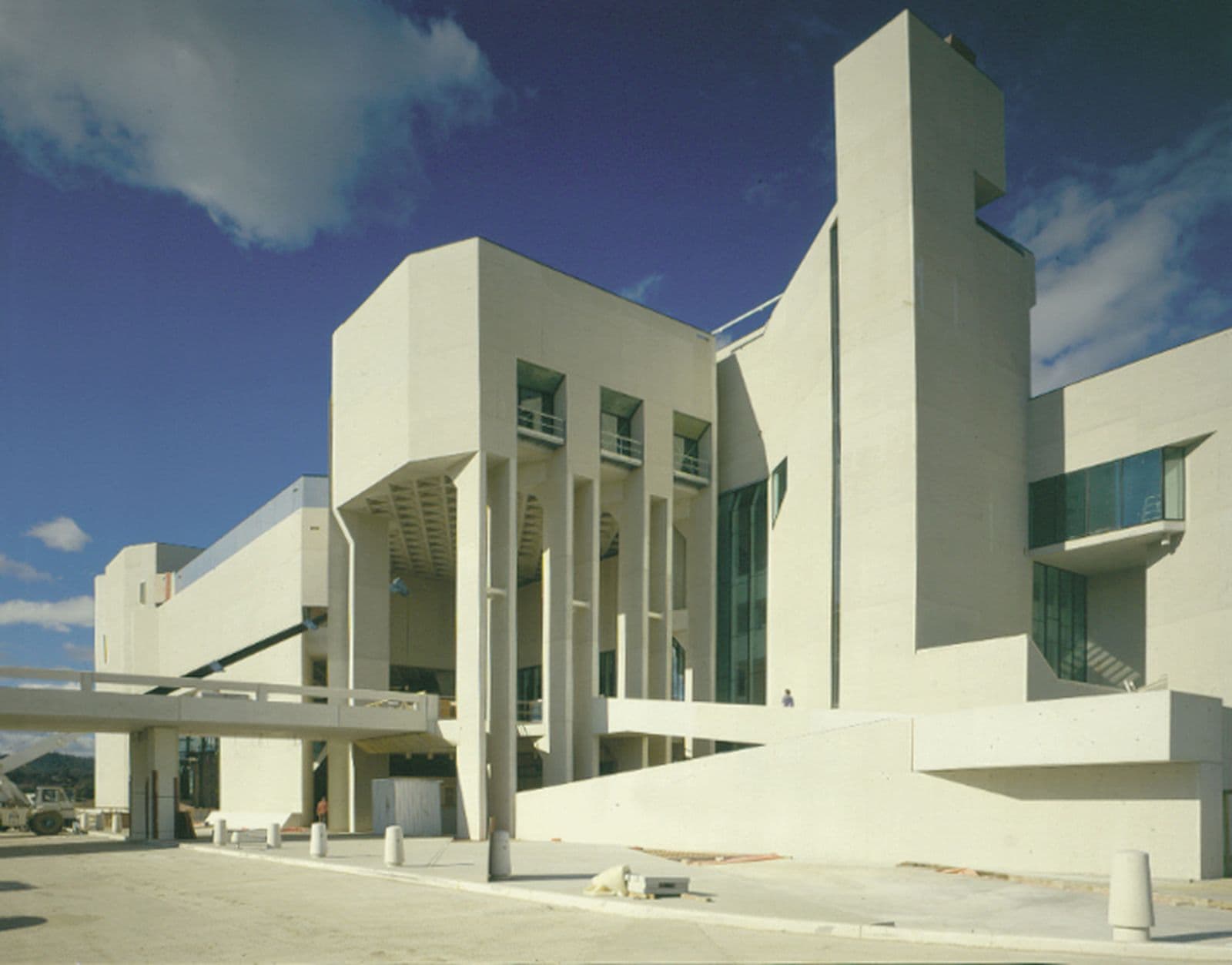 Landscape photo of a largo white concrete building, late in the construction phase