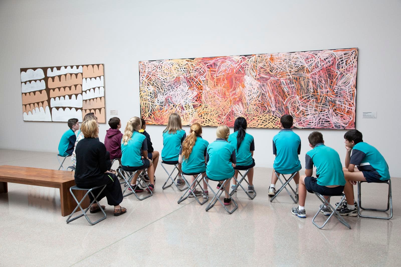 Small group of school children in the first nations galleries viewing Emily Kame Kngwarreye’s Yam awely.