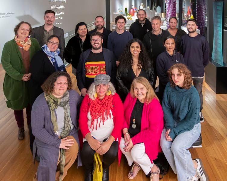 A group of people pose in a group facing the camera to have their photo taken