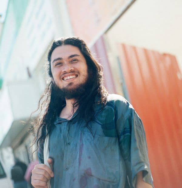 Portrait image of young man with long dark hair and beard