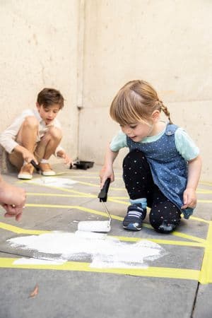 2 kids painting a mural