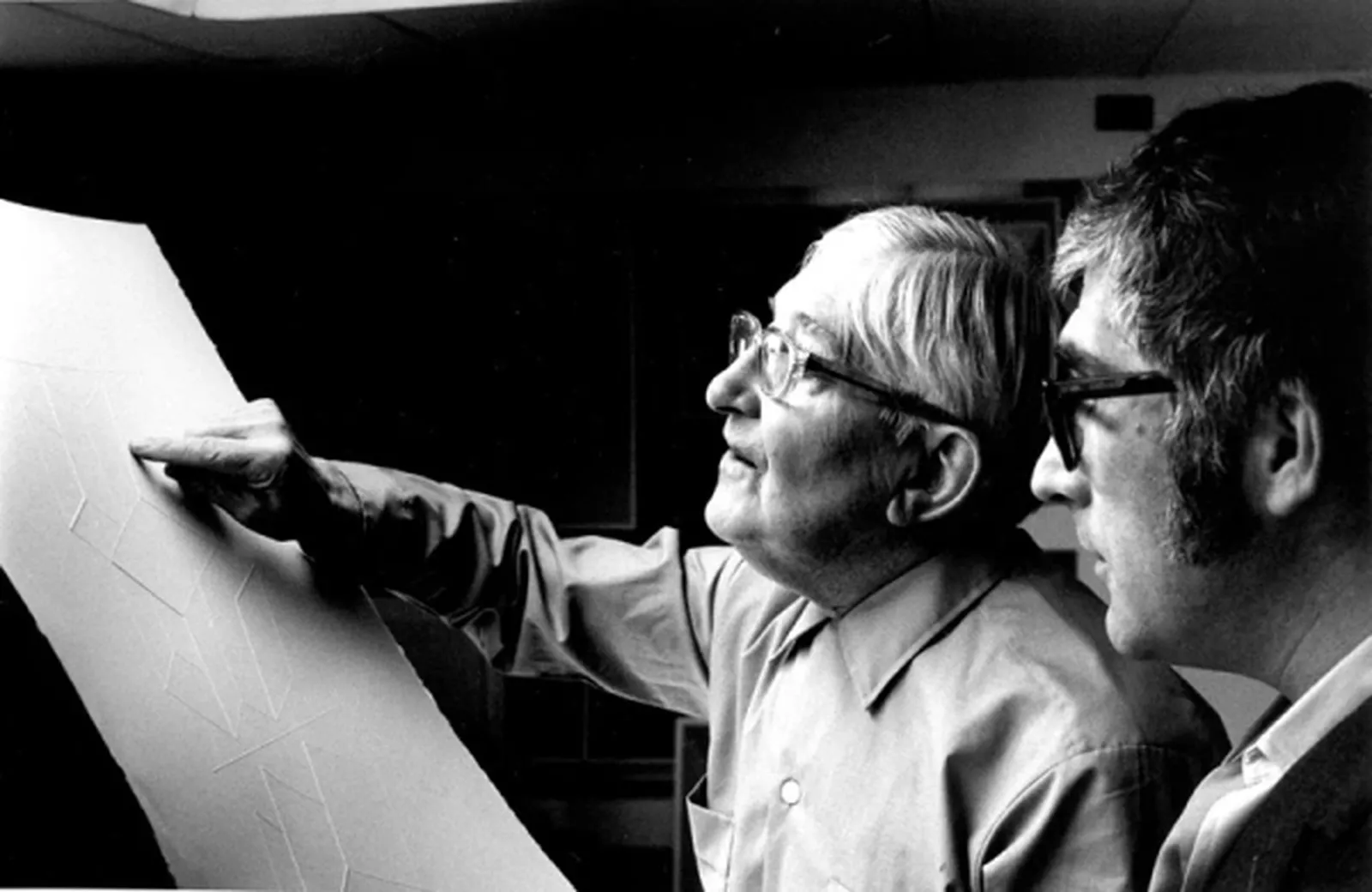 Black and white photograph of Tyler and Albers working on a print