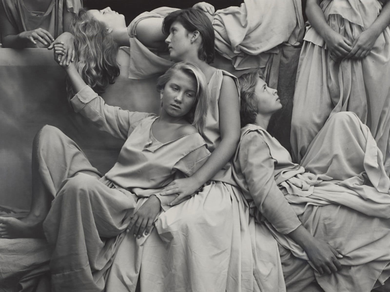 A black and white photograph of women posed like greek statues