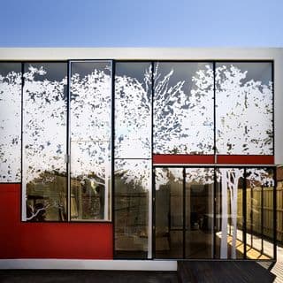 Photograph of glass building with white trees and the red squares drawn on