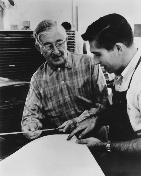 Black and white photograph of Tyler and Albers discussing a print