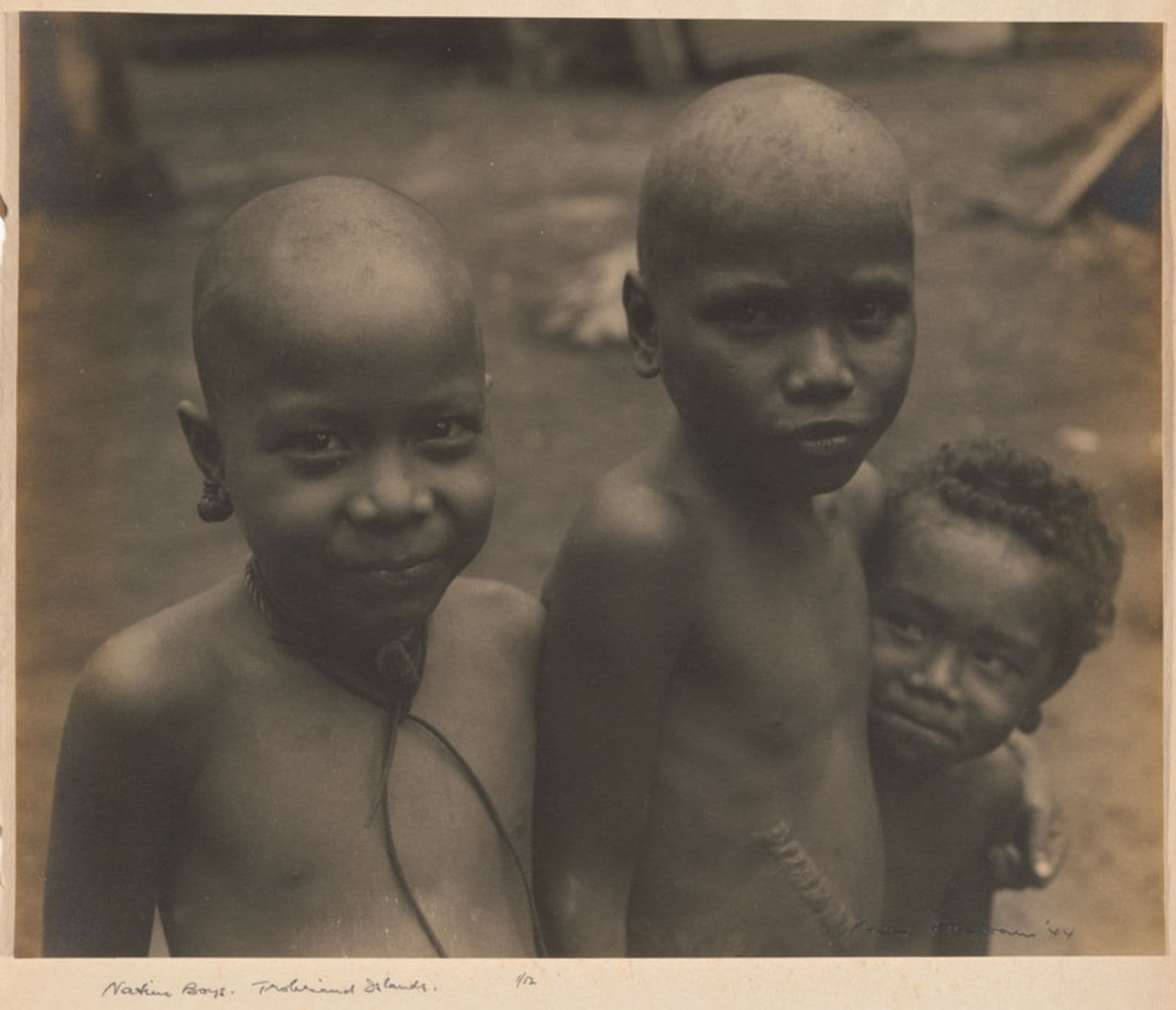 Photograph of three boys. Two are bald but the youngest has curly hair.