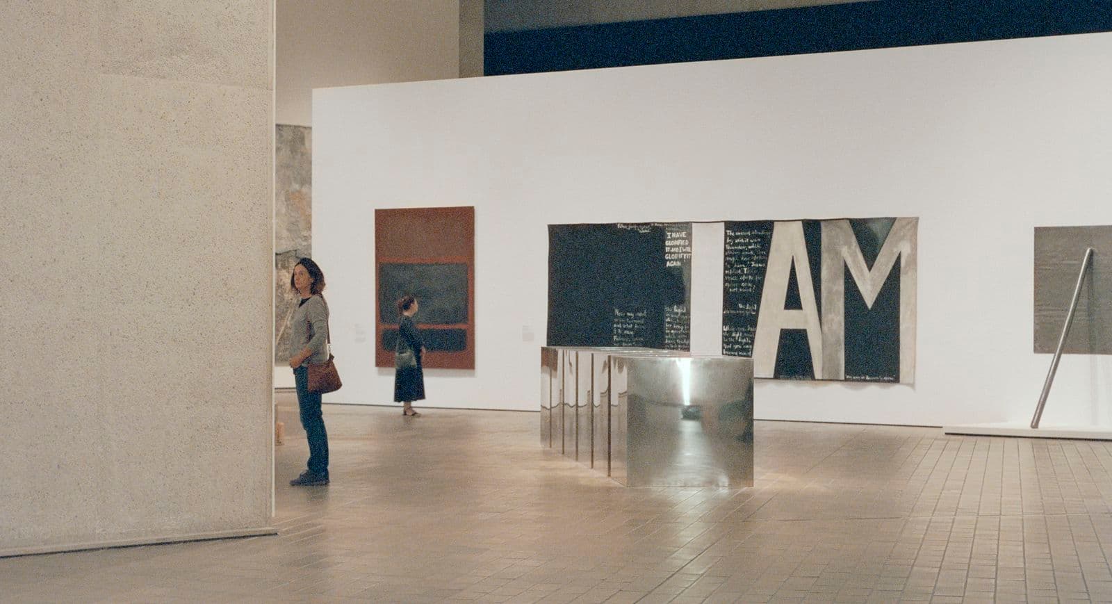 Image of gallery space with visitors viewing artworks