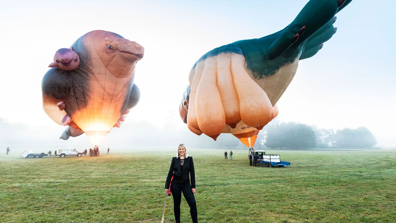 photo of Jess Green holding guitar in front of skywhale balloons