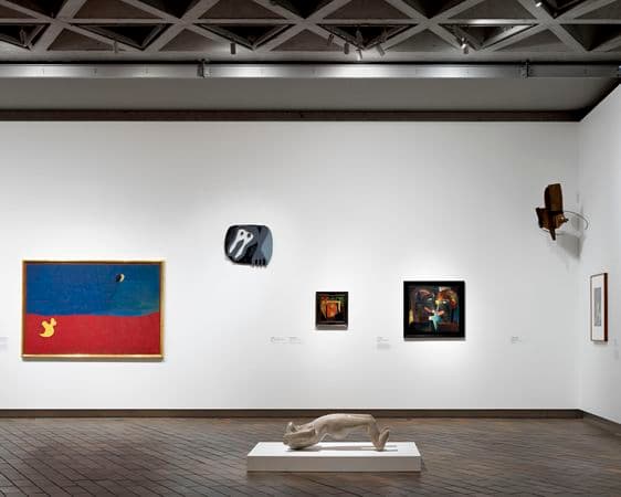 Photograph of gallery wall with paintings hanging