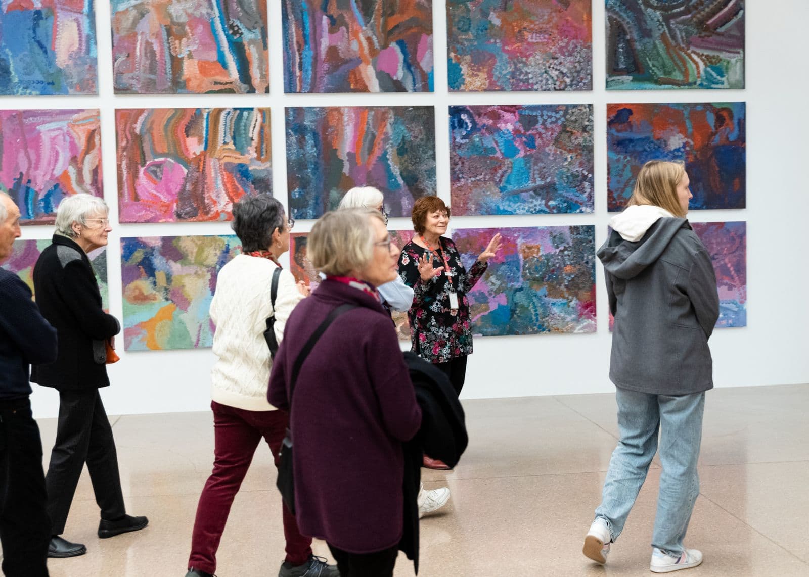 Photo of a group of people in front of paintings