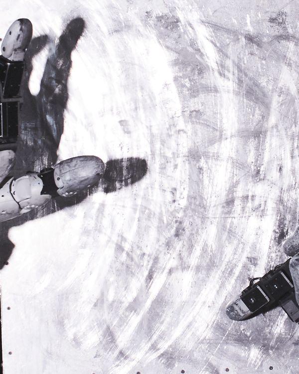 A tight crop of a black and white picture depicting robotic hands clawing