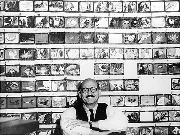 Black and white image of Jules Engels in front of his works