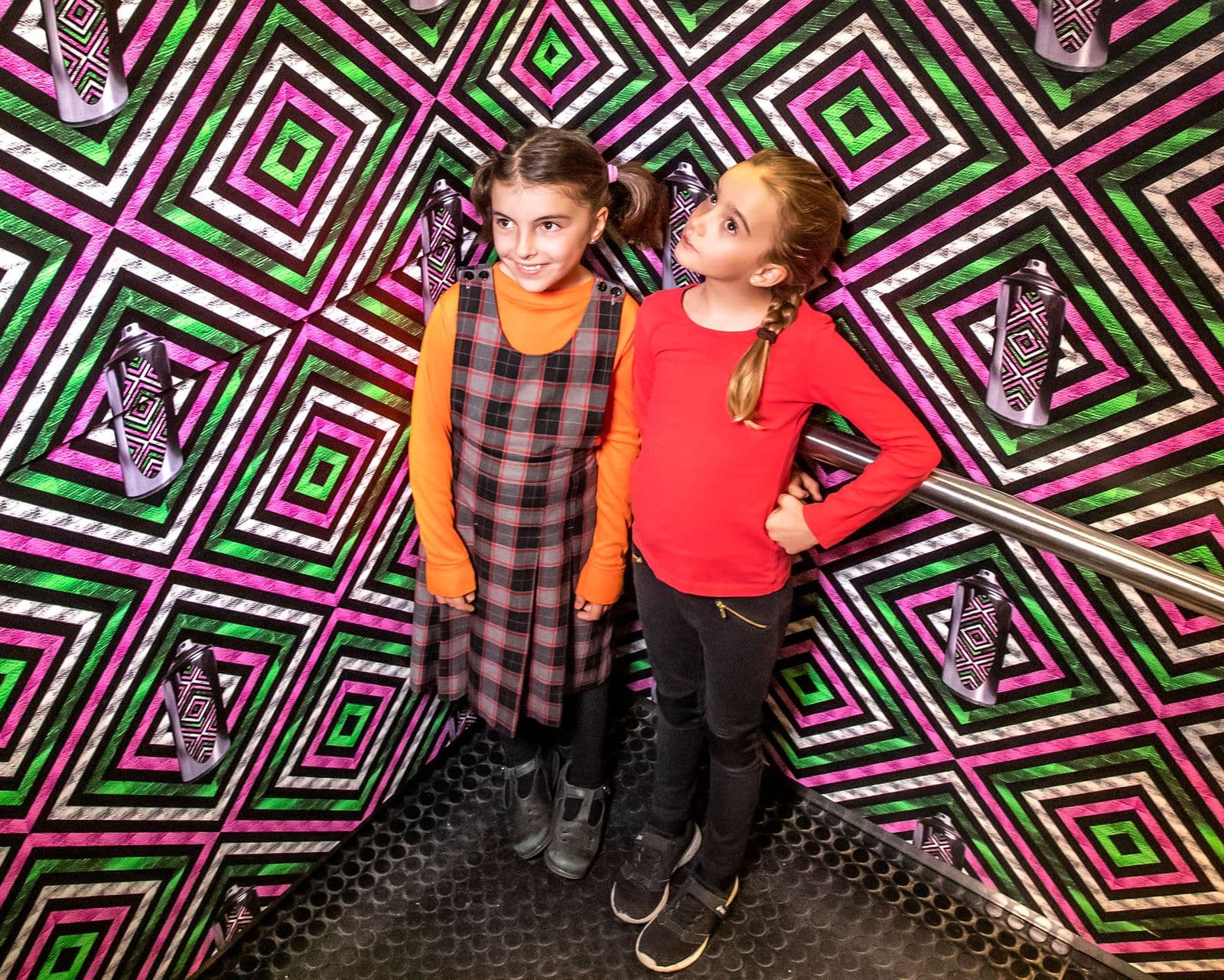 Photograph of two girls in colourful patterned elevator